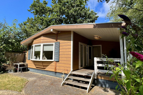 Buitenzicht op een klein familiechalet, Small family chalet close to beach, te midden van natuur.