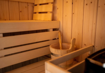 Indvendig træsauna med bænk, træslev og spand på Holiday home i Haarle nær Sallandse Heuvelrug, Holland.