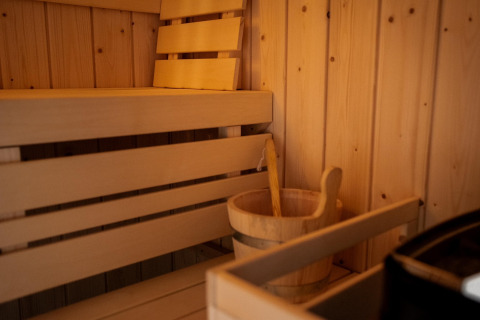 Indvendig træsauna med bænk, træslev og spand på Holiday home i Haarle nær Sallandse Heuvelrug, Holland.