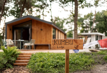 Cabaña de madera con letrero 'Kumbu Lodge', ubicada cerca del Sallandse Heuvelrug en los Países Bajos.