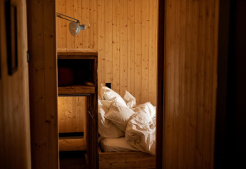 Chambre lambrissée avec lits superposés et draps en désordre à Holiday home à Haarle près de Sallandse Heuvelrug.