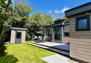 Modern chalet voor 5 personen met tuin, terras en tuinhuisje, omringd door bomen in Nederland.