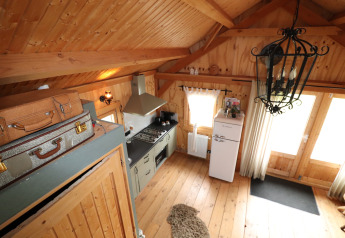 Knusse houten lodge in Nederland met vintage koffers, retro koelkast en sfeervolle houten afwerking.