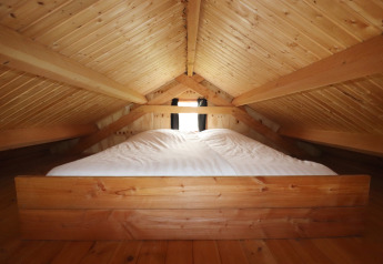 Gezellige zolderslaapkamer met houten balken en bed in Frisian Hideaway with Style in Nederland.