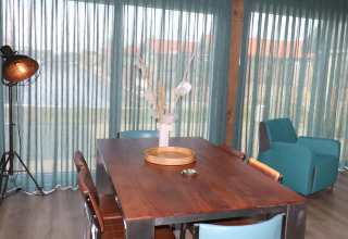 Comedor moderno en Scenic Stay with en los Países Bajos, con mesa de madera y cortinas azules.