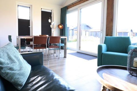 Luminoso salón con muebles modernos y grandes ventanales en la 'Scenic Stay with' en los Países Bajos.