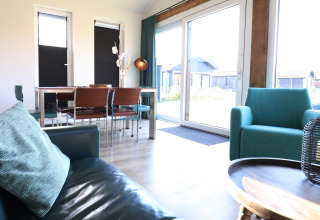 Luminoso salón con muebles modernos y grandes ventanales en la 'Scenic Stay with' en los Países Bajos.