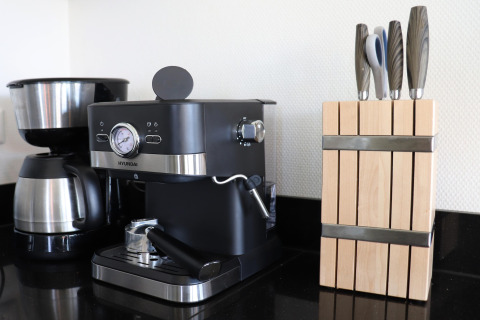 Cafetera, máquina de espresso y bloque de cuchillos en la cocina de la casa Scenic Stay with en Países Bajos.