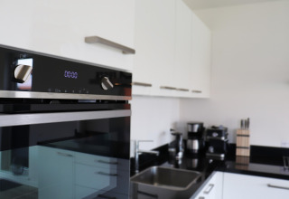 Cocina moderna con horno y cafetera en Scenic Stay, una acogedora casa en los Países Bajos.