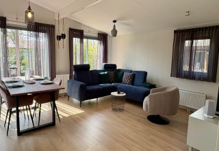 Modern eingerichtetes Wohnzimmer und Essbereich im Chalet nahe dem Strand Sint Maartenszee, Niederlande.