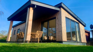 Et moderne chalet i Sint Maartenszee nær Sandy Beach, med store vinduer og udendørs siddepladser.