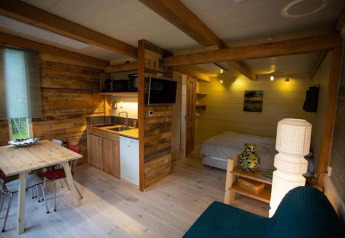 Charmantes Chalet in Sint Maartenszee, Niederlande mit Küchenzeile, Holzmöbeln und gemütlichem Bett.