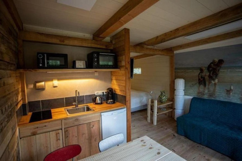 Acogedor interior del Charming Chalet en Sint Maartenszee, Países Bajos, con cocina y área de cama.