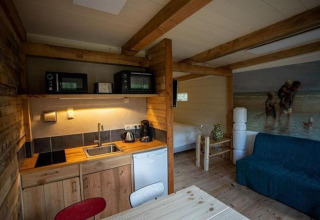 Hyggeligt interiør i Charming Chalet i Sint Maartenszee, Nederlandene, med køkken og seng.