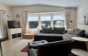 Wohnzimmer eines kleinen Familienchalets nahe dem Strand in den Niederlanden mit Sofa und TV.