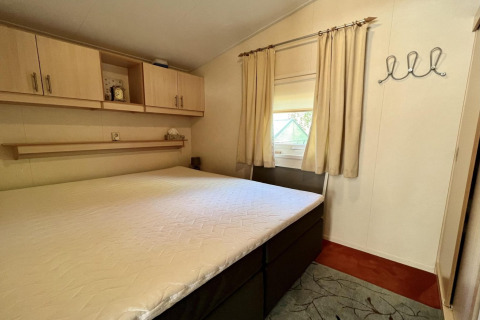 Helles Schlafzimmer im kleinen Familienchalet nahe dem Strand in den Niederlanden mit Doppelbett.