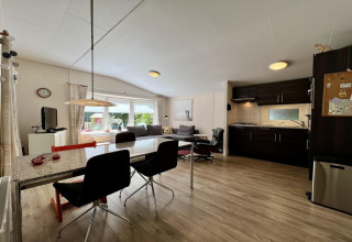 Lichte leefruimte in een klein familiechalet dicht bij het strand in Nederland met moderne keuken.
