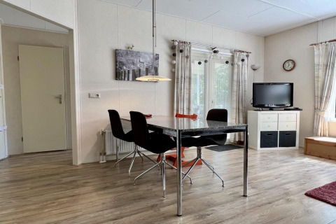 Sala luminosa en un pequeño chalet familiar cerca de la playa en los Países Bajos con mesa y televisor.