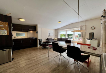 Woonruimte en keuken in een klein familiechalet dicht bij het strand in Nederland, modern ingericht.