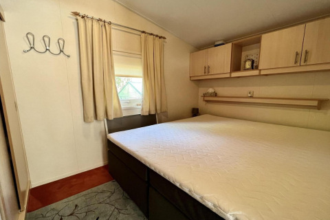 Camera da letto in un piccolo chalet familiare vicino alla spiaggia nei Paesi Bassi con letto grande.