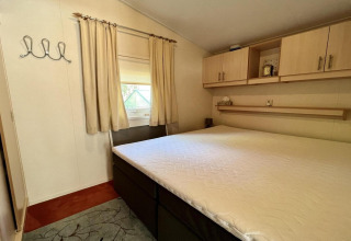 Dormitorio de un pequeño chalet familiar cerca de la playa en los Países Bajos, con cama grande y armarios.
