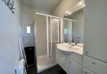 Badezimmer in einem kleinen Familienchalet nahe dem Strand in den Niederlanden mit Dusche und Waschbecken.