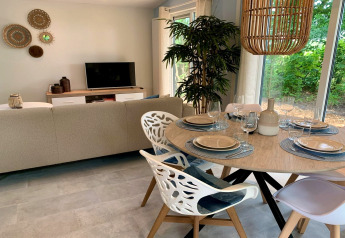 Modern chalet in Nederland met stijlvolle eetkamer, grote ramen en uitzicht op groene natuur buiten.