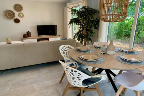 Chalet moderno nei Paesi Bassi con soggiorno, tavolo da pranzo e vista su un giardino verdeggiante.