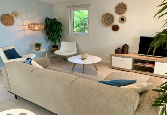 Stilfuld stue i moderne chalet med beige sofa, hvide stole og naturlige dekorationer i Holland.