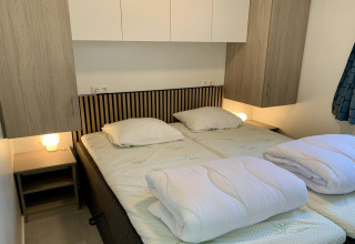 Modern chalet met terras en veranda in Nederland, met twee eenpersoonsbedden en nachtkastjes.