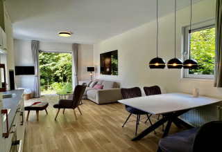Moderne leef- en eetruimte in Unique chalet for 5 met panoramische ramen en tuinzicht, Nederland.