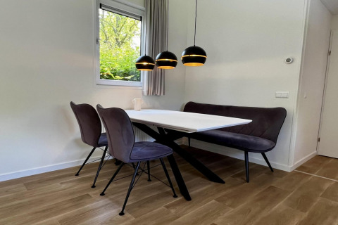 Moderner Essbereich mit schwarzen Lampen und weißen Wänden in 'Unique chalet for 5' in den Niederlanden.