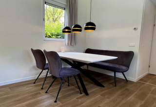Moderne eethoek met zwarte lampen en bankje in 'Unique chalet for 5 met tuin' in Nederland.