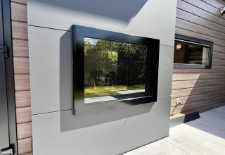 Moderne buitenmuur met groot zwart kozijn bij Unique chalet for 5 with garden in Nederland