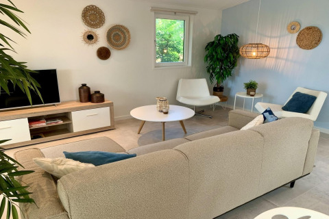 Moderne chalet woonkamer met lichte decoratie, gezellige zithoek en wandmanden in Nederland.