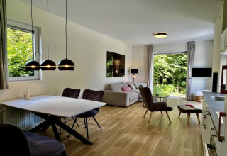 Salón moderno en chalet único para 5 personas con grandes ventanas y vista al jardín en los Países Bajos.
