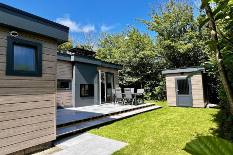Uniek chalet voor 5 personen met tuin, terras en tuinhuis, zonnig gelegen in Nederland, omringd door groen.