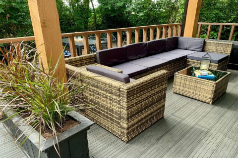 Moderne Terrasse mit geflochtenen Sitzmöbeln und Pflanzen in einem Chalet in den Niederlanden.