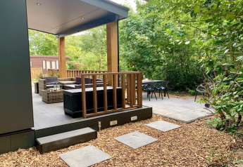 Moderne chalet met terras en veranda, buitenzitje omgeven door groen in Nederland.