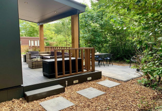 Chalet moderno con terrazza e veranda, area salotto all'aperto immersa nel verde nei Paesi Bassi.