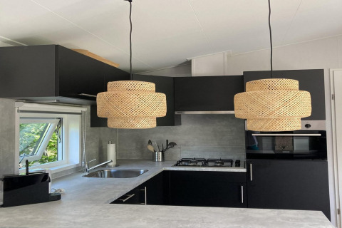 Modernes Chalet-Küche in den Niederlanden mit schwarzen Schränken, runden Lampen und Fenster.