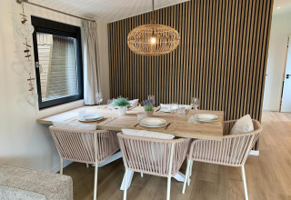 Coin repas d’un chalet agréable aux Pays-Bas avec table dressée, revêtement bois et décoration moderne.