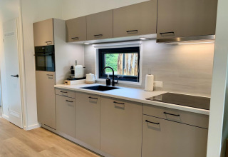 Cocina moderna en Pleasant Chalet con veranda en Países Bajos, electrodomésticos y ventana.