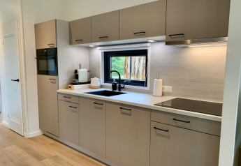 Cocina moderna en Pleasant Chalet con veranda en Países Bajos, electrodomésticos y ventana.