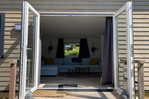 Billede af hytten 'Modern chalet with garden, terrace' i Holland, med åbne glasdøre og udsigt til stue.