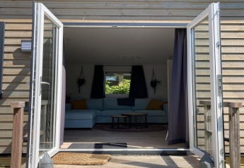 Vista a través de puertas abiertas al salón del 'Modern chalet with garden, terrace' en los Países Bajos.
