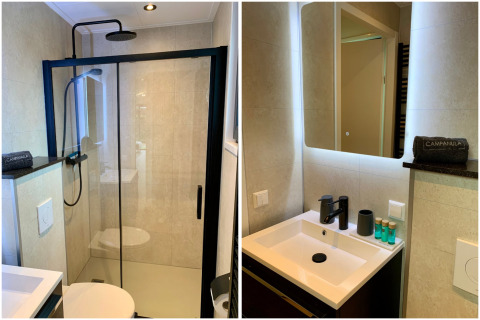 Salle de bain moderne du Pleasant chalet aux Pays-Bas, avec douche, robinet noir et miroir éclairé.