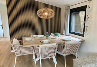Moderner Essbereich im 'Pleasant chalet with veranda' in den Niederlanden mit Holzdekor und Hängeleuchte.