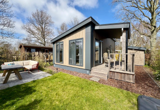 Modernes Chalet nahe dem Strand Sint Maartenszee in den Niederlanden mit Terrasse und Gartenmöbeln.