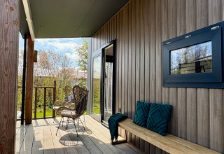 Acogedora terraza en el Chalet cerca de la playa Sint Maartenszee en Países Bajos con sillas y banco.